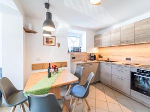 Una cocina con una mesa y sillas de madera. en Apartment Evi by Interhome, en Hollersbach im Pinzgau