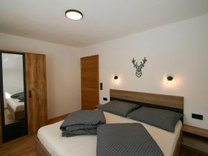 a bedroom with a bed and a mirror at Apartment Ferienwohnung Selina by Interhome in Fügenberg