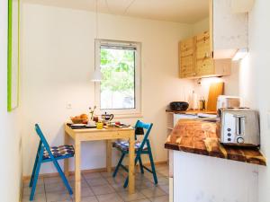 a kitchen with a wooden table and blue chairs at Schwalbenhof Kagar in Kagar