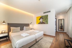 里斯本VIP Executive Picoas Hotel的卧室配有一张大床,墙上挂有绘画作品 更多27张照片