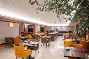 里斯本VIP Executive Picoas Hotel的一间带桌椅的用餐室和一间餐厅