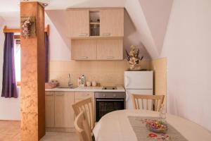 a kitchen with a table and a white refrigerator at Vila Zlatna Pahulja in Bajina Bašta +6 photos