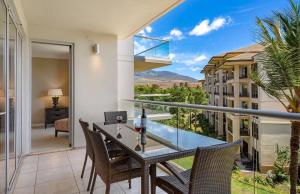 a balcony with a table and chairs with a view at Honua Kai Resort And Spa By Maui Resort Rentals in Lahaina