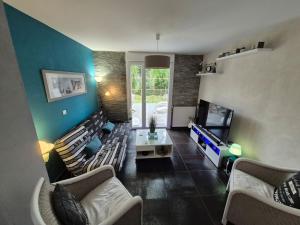Una sala de estar con sofás y un televisor de pantalla plana. en Maison d Angele 4 chambres, en Chambray-lès-Tours