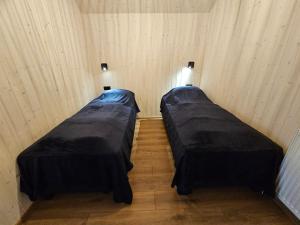 2 Betten in einem kleinen Zimmer mit in der Unterkunft Úthlíd Cottages in Úthlid