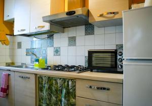 a kitchen with a stove and a microwave at Da zia Concetta, casa vacanze immersa nel verde in Colledara
