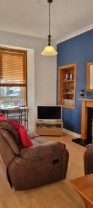 a living room with a couch and a tv at Brucefield Avenue, Dunfermline in Dunfermline