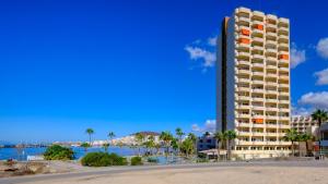 une vue d'un hôtel et de la plage avec un bâtiment dans l'établissement Apartamentos Costamar, à Los Cristianos