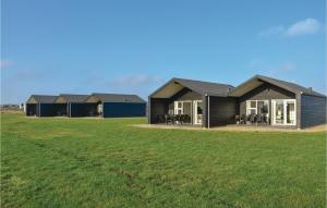 a row of houses in a field with a grass field at Two-Bedroom Holiday Home Ringkøbing 09 in Søndervig