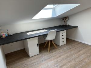 una scrivania con sedia in una stanza con finestra di Duplex 45m2 avec SDB - WC a Saint-Thomas