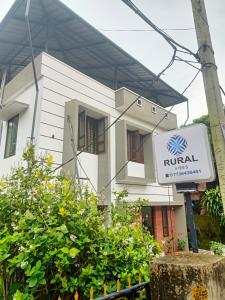 a white building with a sign in front of it at Rural Vibes in Varkala +16 photos