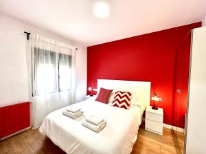 ein Schlafzimmer mit einer roten Wand und einem weißen Bett in der Unterkunft Ever House - ALCALA DIVA 1 ROOFTOP in Madrid