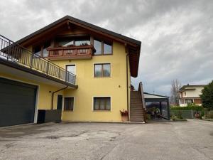 a yellow house with a balcony on top of it at B&B casa Orsingher a 2 passi da Belluno in Trichiana +9 photos