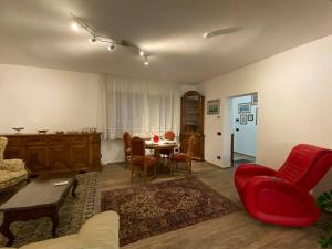 a living room with a red couch and a table at B&B casa Orsingher a 2 passi da Belluno in Trichiana