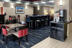a restaurant with a bar and tables and chairs at Comfort Inn & Suites Jackson North in Jackson