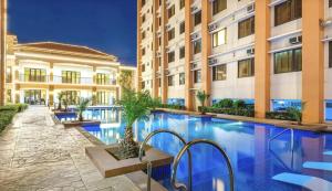 a swimming pool in front of a building at Angsana Breeze at Paseo Verde Las Piñas in Manila