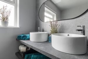 a bathroom with a large white sink and a mirror at Elegant Malvhina Retreat on the Malvern Hills in Great Malvern +32 photos