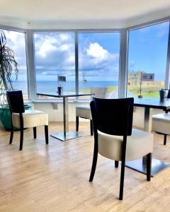 Habitación con mesa, sillas y vistas al océano. en Cape Cornwall Club, en St Just