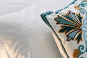 a close up of a pillow with a flower on it at Mercedes Country House in Faro