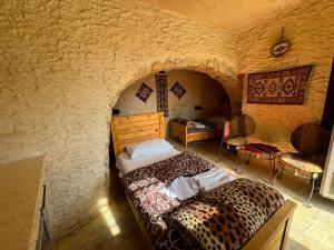 Ein Schlafzimmer mit einem Leopardenmusterbett in einer Steinwand in der Unterkunft Dana Tower Hotel in Dana