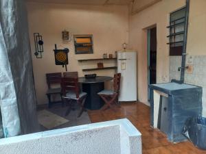 a kitchen with a table and chairs and a refrigerator at Edicula beira praia, lulumar in Itanhaém