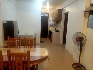 a dining room and kitchen with a table and a fan at 017 Baguio Transient in Baguio