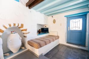 a bedroom with a bed and a blue door at Margarita's Houses in Astypalaia Town