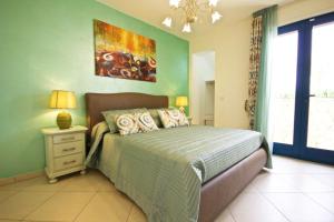 ein Schlafzimmer mit einem Bett und einem Gemälde an der Wand in der Unterkunft Villa Panoramica 5 in Torre Pali 