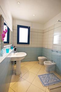 ein Badezimmer mit Waschbecken und Toilette in der Unterkunft Villa Panoramica 5 in Torre Pali  + 14 Fotos