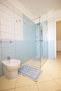 ein Badezimmer mit Toilette und Glasdusche in der Unterkunft Villa Panoramica 5 in Torre Pali 