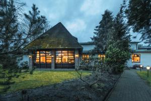 a house with a large window in a yard at Hotel Rosenheim in Schwentinental