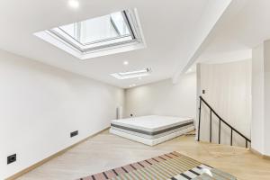 een slaapkamer met een bed en een dakraam bij Maison atypique de 82 m2 sur 4 niveaux proche Saint Mande in Vincennes