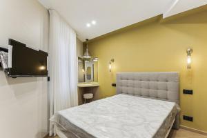 een slaapkamer met een bed en een tv aan de muur bij Maison atypique de 82 m2 sur 4 niveaux proche Saint Mande in Vincennes