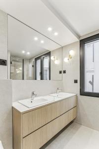 een badkamer met twee wastafels en een grote spiegel bij Maison atypique de 82 m2 sur 4 niveaux proche Saint Mande in Vincennes +9 foto's