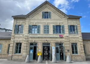 a large stone building with doors and windows at Grand T2 45m2 avec Parking & Balcon proche Paris in Montmagny