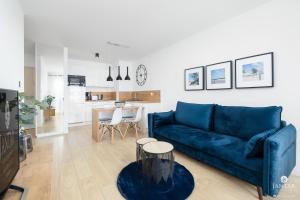 salon z niebieską kanapą i stołem w obiekcie DELUXE 38 Bałtycka 6 by Jantar Apartamenty Kołobrzeg w Kołobrzegu