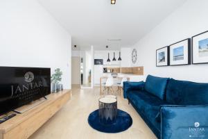 salon z niebieską kanapą i stołem w obiekcie DELUXE 38 Bałtycka 6 by Jantar Apartamenty Kołobrzeg w Kołobrzegu