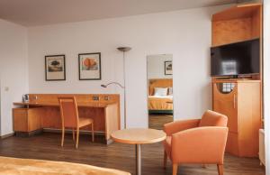 a room with a desk and a table and chairs at Ariva Boardinghouse Platanenhof in Mannheim
