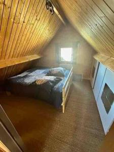 a bedroom with a bed in a wooden attic at Chalet douillet 4 personnes -Proche plage in Merville-Franceville-Plage