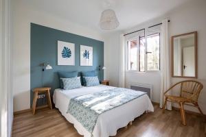 Schlafzimmer mit einem Bett mit blauem Akzent in der Unterkunft Villa Eglantine à deux pas de la plage PYLA SUR MER in La Teste-de-Buch