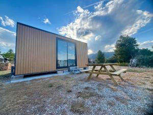 贝塞特Beceite Camping的前面设有野餐桌的木制建筑