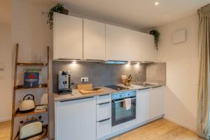a kitchen with white cabinets and a counter top at Design-Apartment in Langenbach bei München, nahe Flughafen München in Langenbach