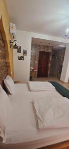 a large white bed in a room with a brick wall at Mahdia - Baghdadi - Laourient Apartments, restaurant, café in Mahdia