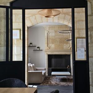 a living room with a couch and a fireplace at Clos des Jacobins (Grand Cru Classé) in Saint-Émilion