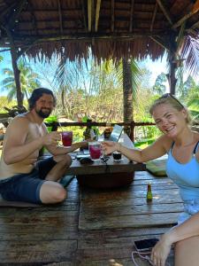 a man and a woman sitting at a table with drinks at Easylife Bungalow in Ko Lanta