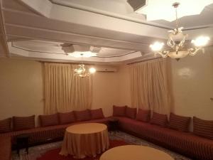 a waiting room with couches and a table at Maison d'hôtes afoulki tafraout in Tafraout