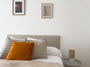 1 cama con almohada naranja y 2 cuadros en la pared en TAYP San Marcos 105, en Talayuela 26 fotos más