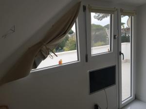 a room with two windows and a tv in a room at Roma - Casalpalocco - Amipsia in Casal Palocco