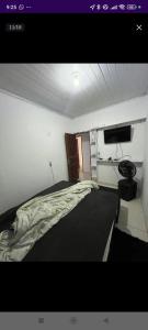 a bedroom with a bed and a flat screen tv at Casa in Brasilia