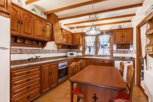 a kitchen with wooden cabinets and a wooden table at Teresita High Views in Santa Brígida